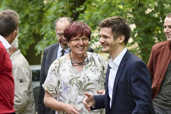 Menschen diskutieren angeregt politische Positionen im Freien