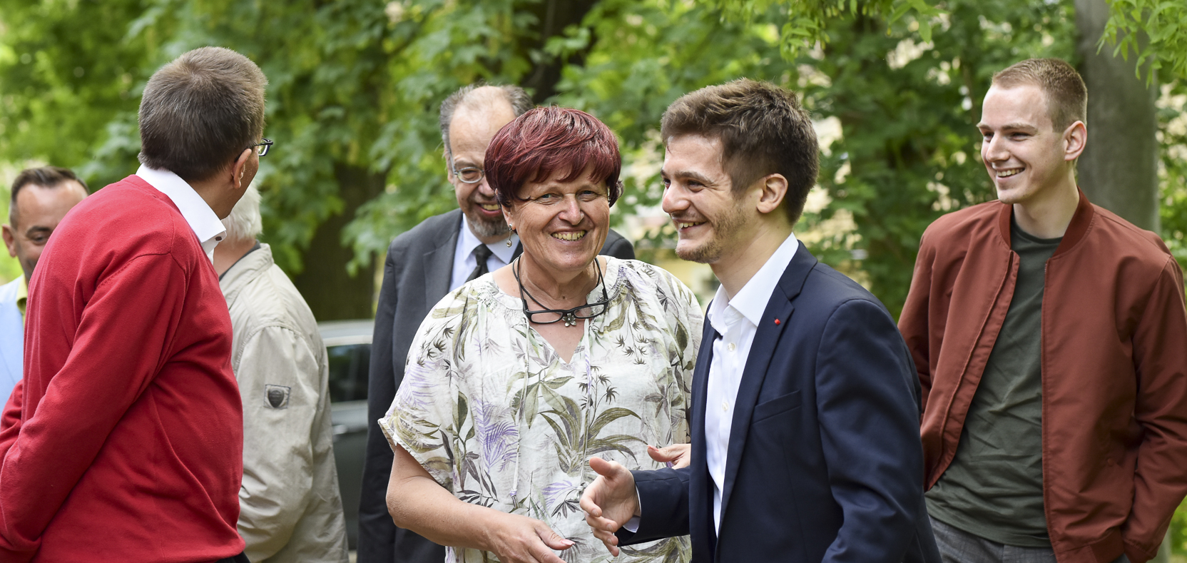 Menschen diskutieren angeregt politische Positionen im Freien